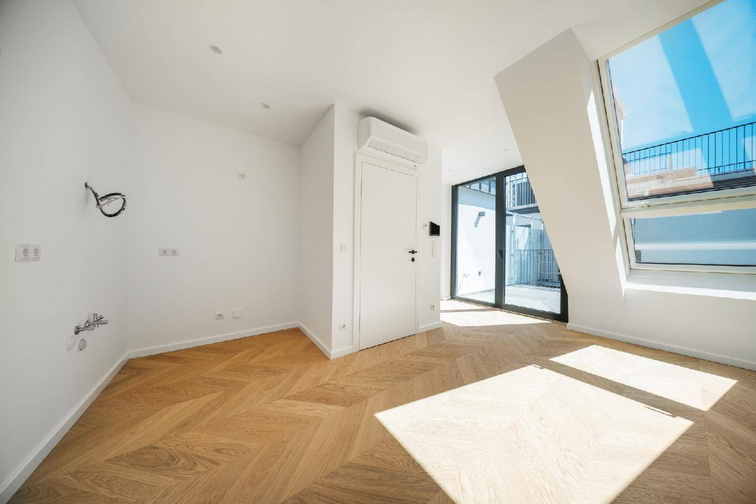 Moderner Wohnraum mit Fischgrätparkett, Klimaanlage und großem Dachfenster für viel Helligkeit.