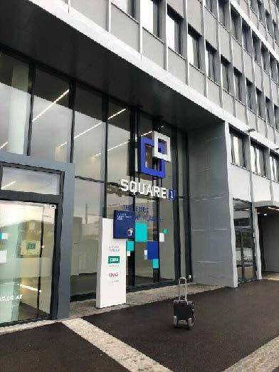 Moderner Eingangsbereich eines Geschäftsgebäudes mit Glasfassade und dem Logo 'SQUARE 1'.