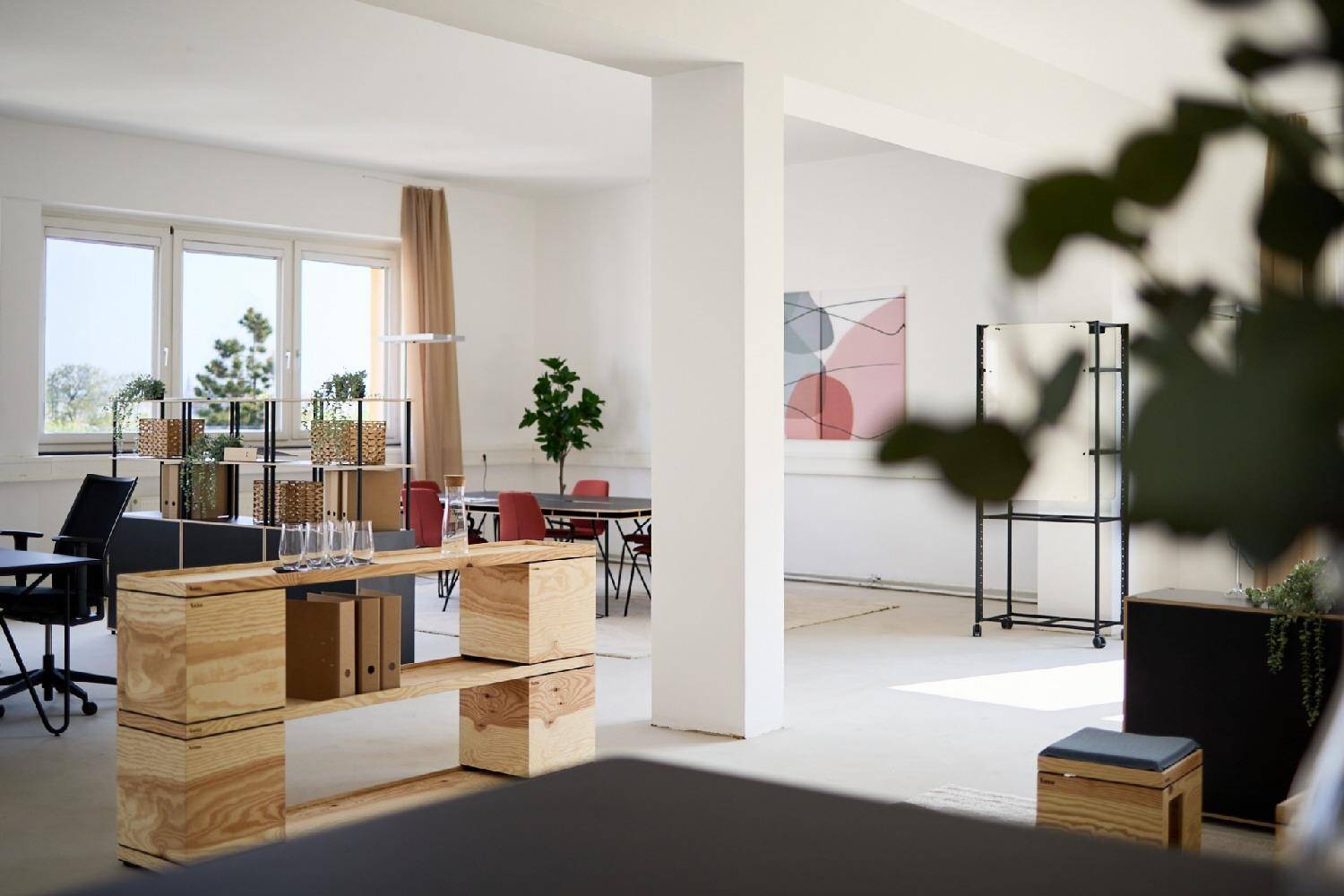 Offenes Büro mit Holzelementen, großen Fenstern und Blick auf die Umgebung.