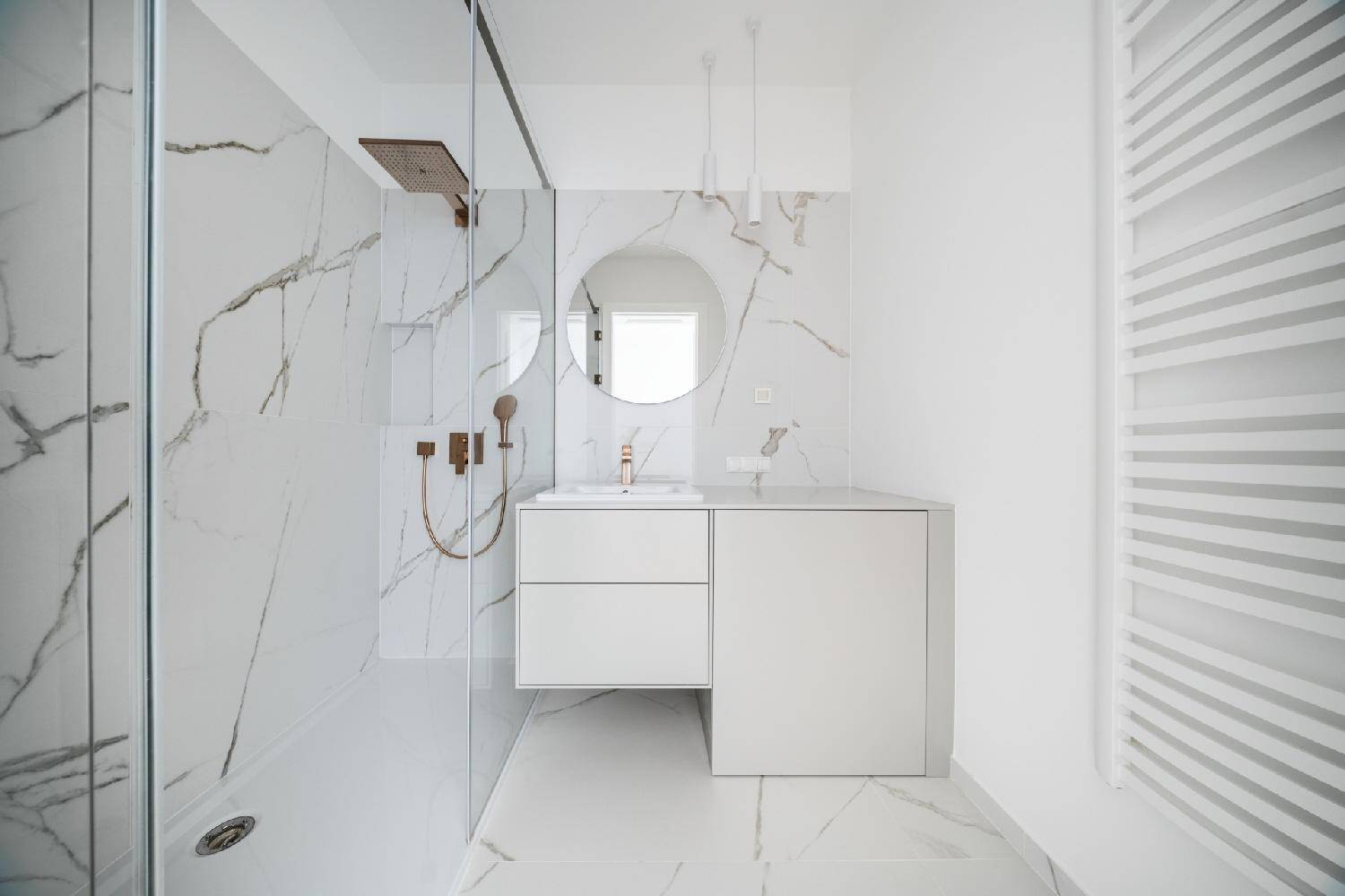 Modernes Badezimmer mit Marmorfliesen, begehbarer Dusche und elegantem Waschtisch.