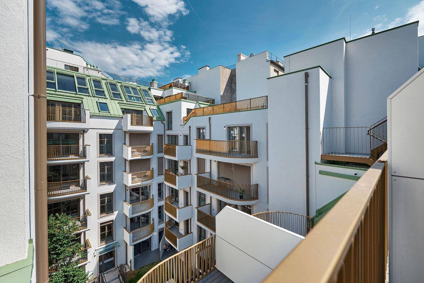 Blick von einem Balkon auf den Innenhof und die moderne Architektur des Wohnkomplexes.