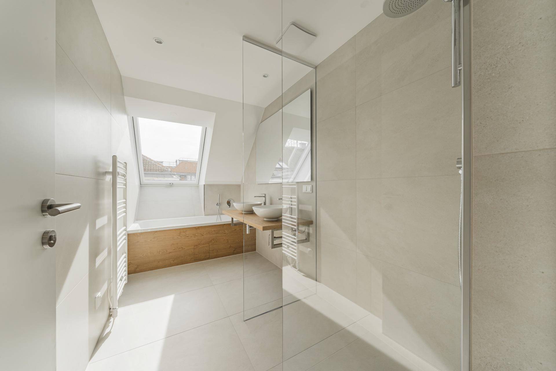 Modernes Badezimmer mit begehbarer Dusche, Badewanne unter dem Dachfenster und Doppelwaschbecken.