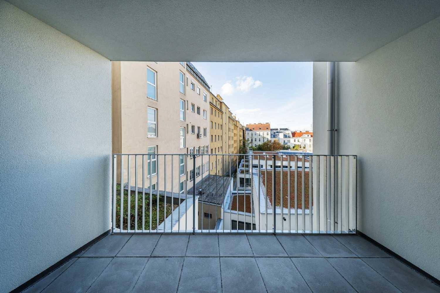Balkon mit Blick auf den Innenhof und die umliegenden Gebäude, mit viel Tageslicht.
