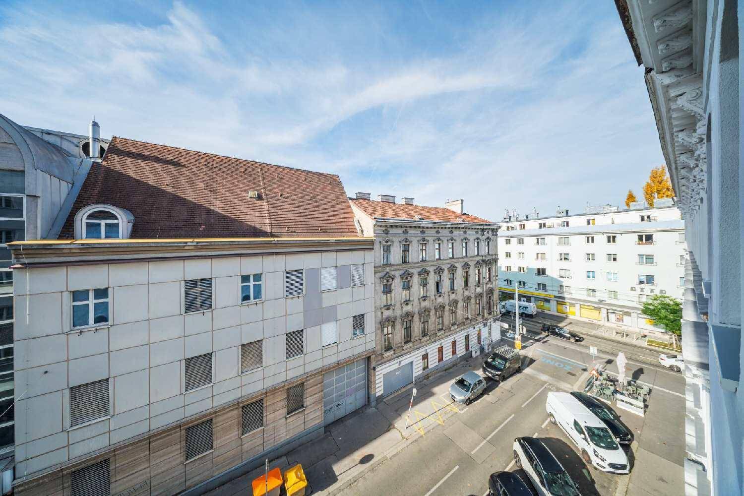 Weitblick über die Stadt mit historischen Gebäuden und belebten Straßen unter blauem Himmel.