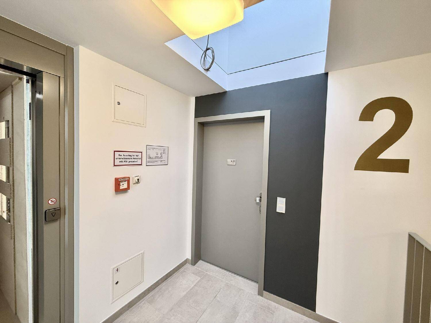 Heller Flur im zweiten Stock mit Aufzug und modernem Design.