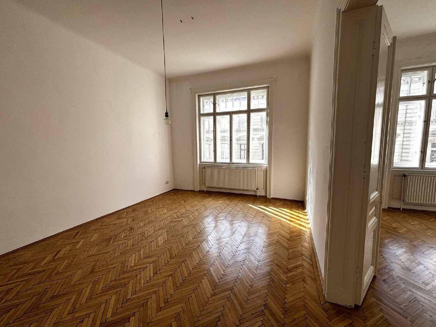 Geräumiges Zimmer mit klassischem Fischgrätparkett und einem großen Fenster, das den Raum erhellt.