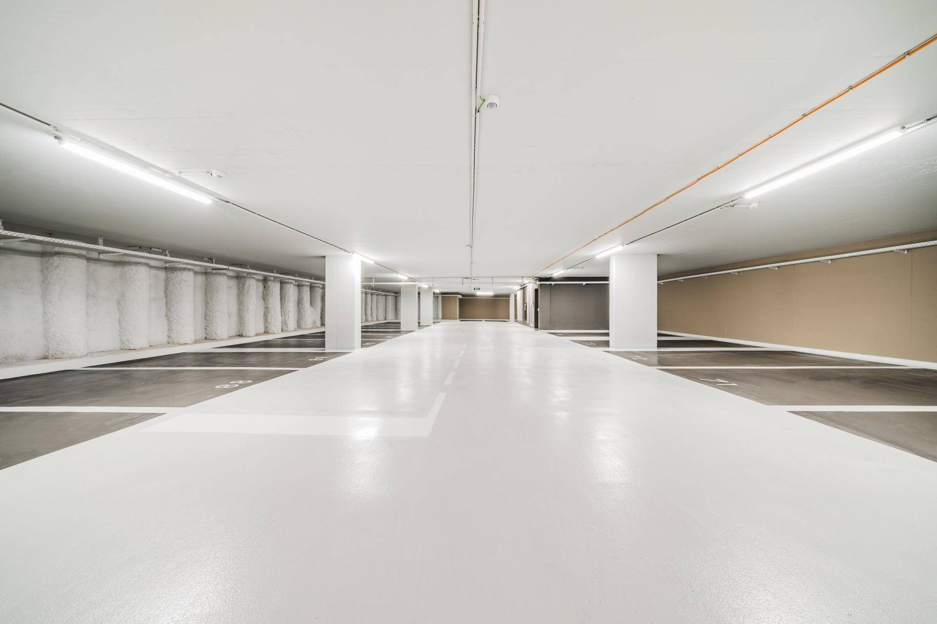 Helle und geräumige Tiefgarage mit vielen Parkplätzen und guter Beleuchtung.