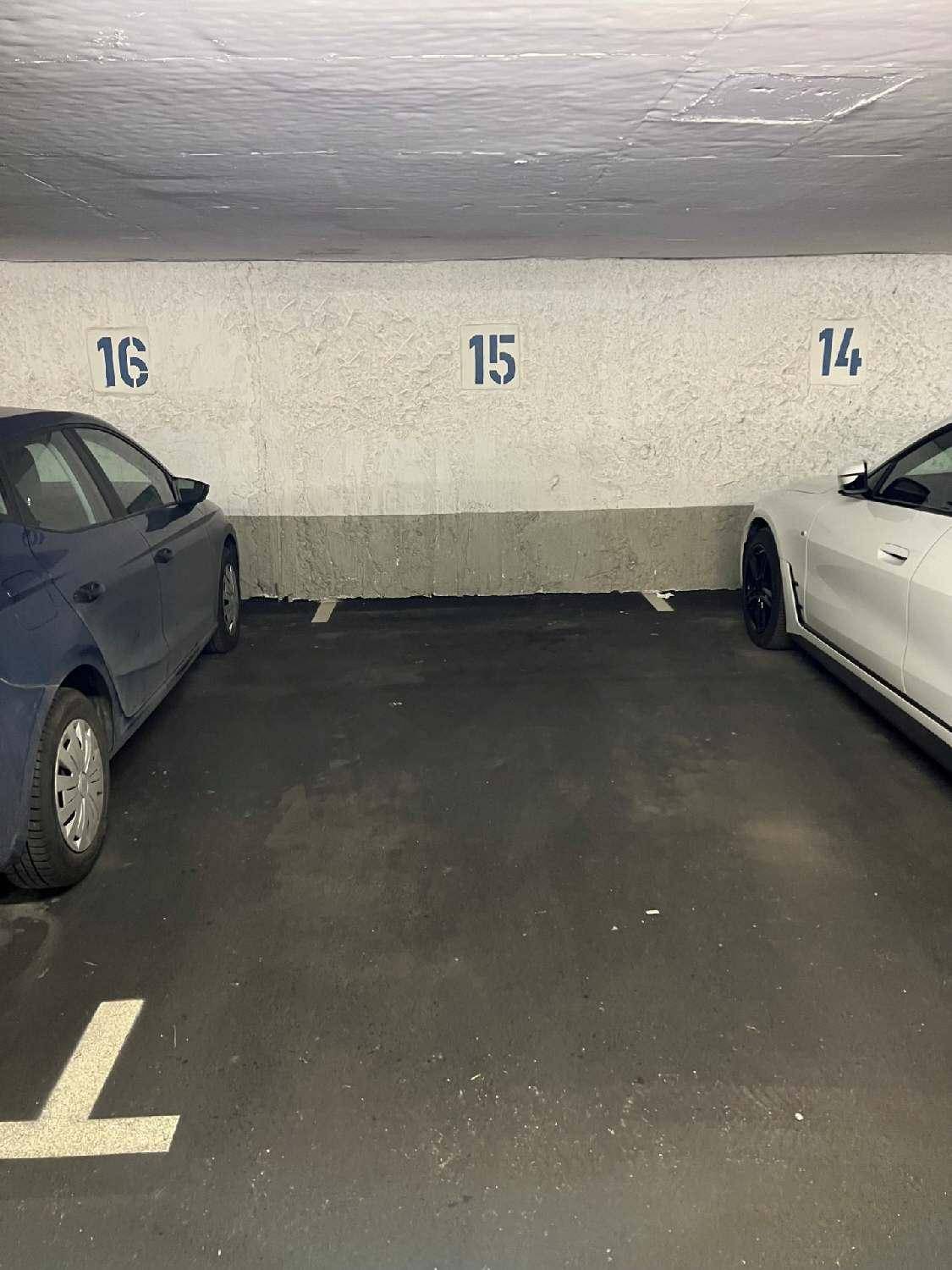 Tiefgarage mit nummerierten Stellplätzen und geparkten Fahrzeugen, gut beleuchtet.