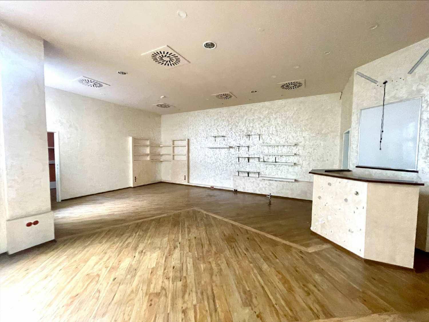 Heller Verkaufsraum mit Holzboden, Wandregalen und einer Theke im Vordergrund.