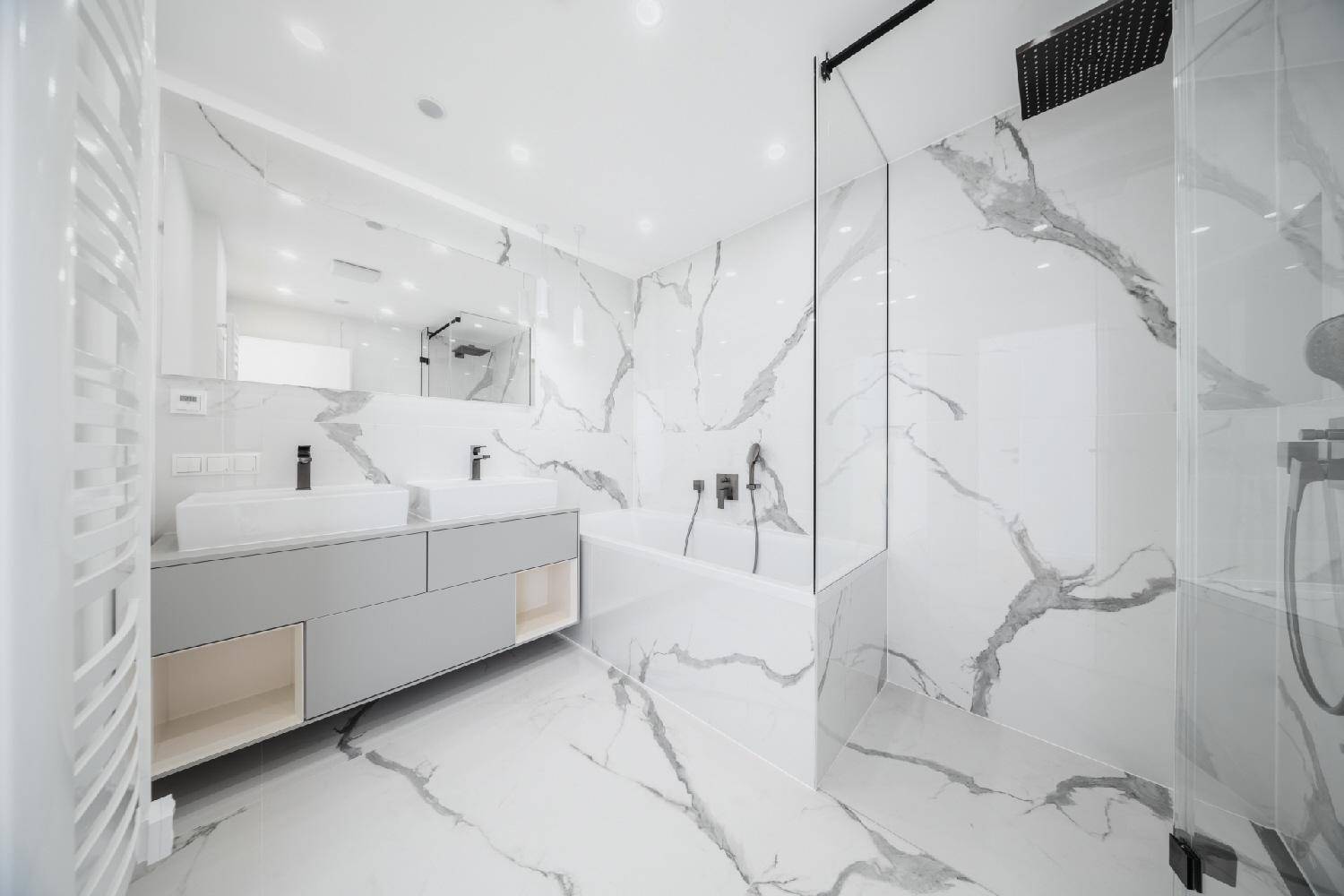 Luxuriöses Badezimmer mit Marmorfliesen, Doppelwaschbecken, Badewanne und großer begehbarer Dusche.