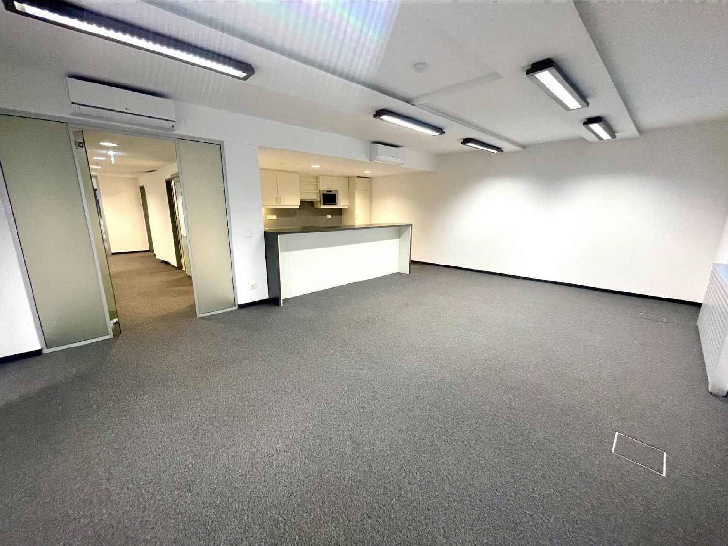 Offener Bürobereich mit integrierter Küchenzeile, Teppichboden und Klimaanlage.