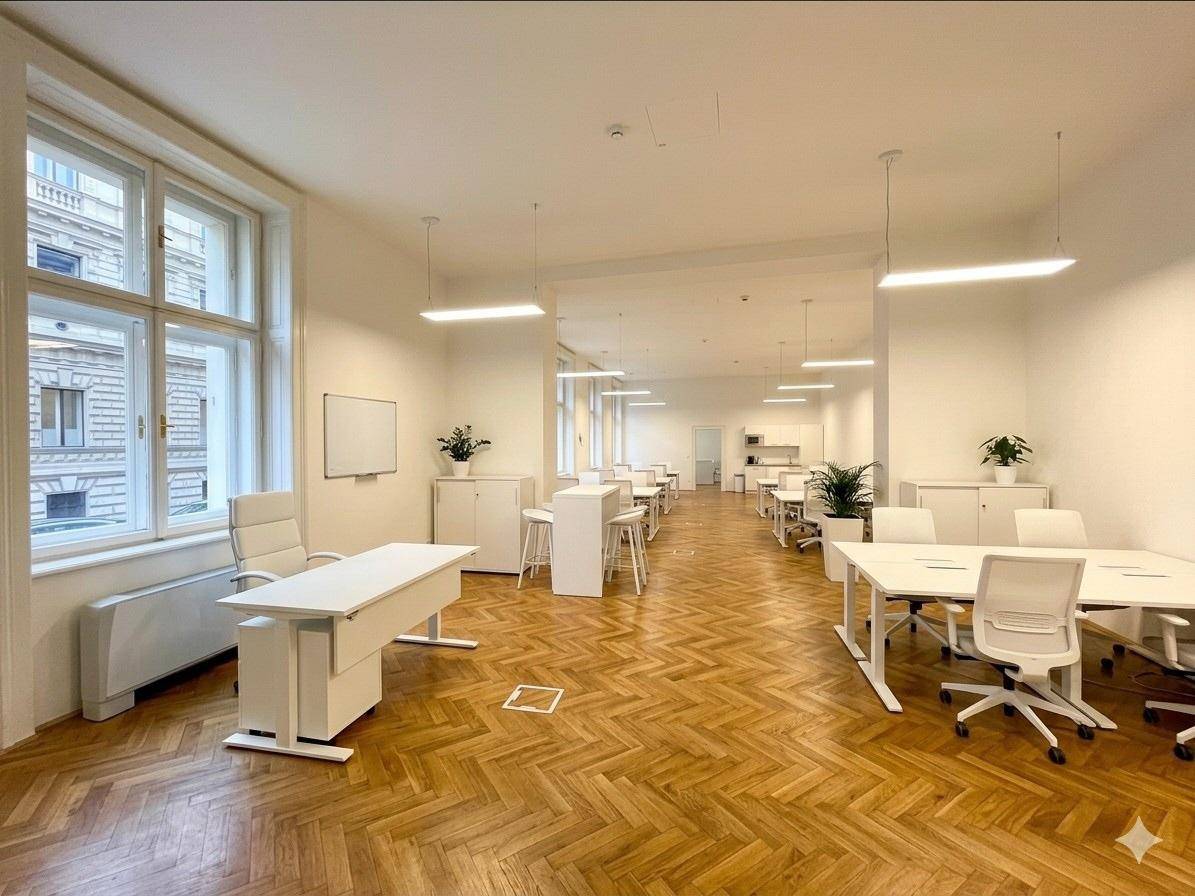 Geräumiges, helles Büro mit Fischgrätparkett, großen Fenstern und moderner Einrichtung für zahlreiche Arbeitsplätze.