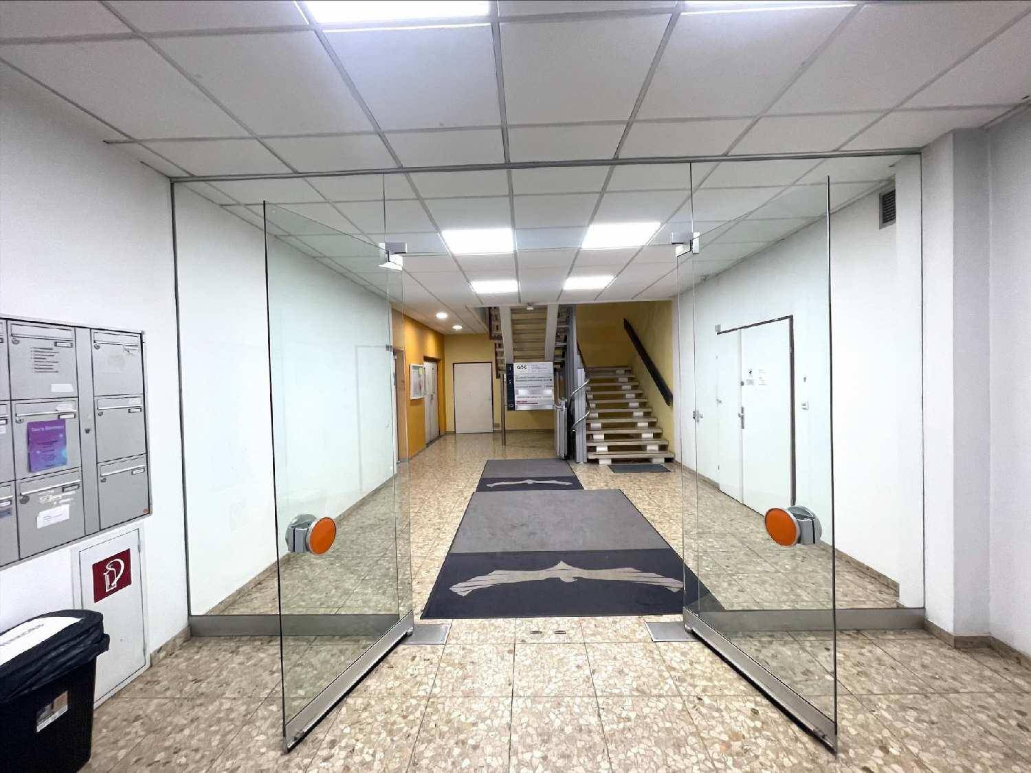 Eingangsbereich mit großen Glastüren, Briefkästen und Blick auf den Flur mit Treppe.