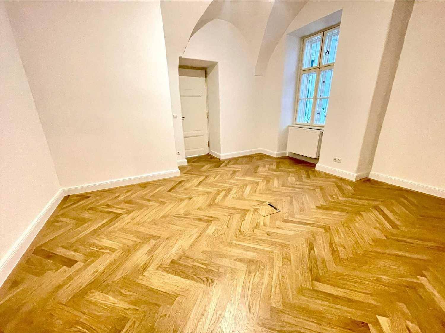 Heller Raum mit Fischgrätparkett und einem gewölbten Deckenabschnitt, der einen besonderen Charme verleiht.