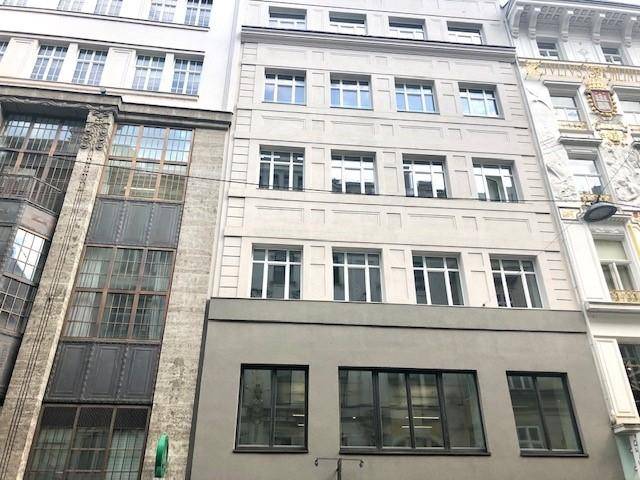 Moderne Gebäudefassade mit vielen Fenstern und schlichter Architektur in urbaner Umgebung.