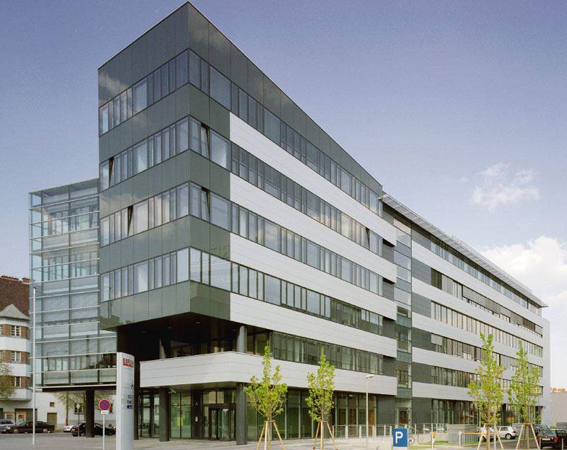 Modernes Bürogebäude mit einer Mischung aus grauen und weißen Fassadenplatten und vielen Fenstern.
