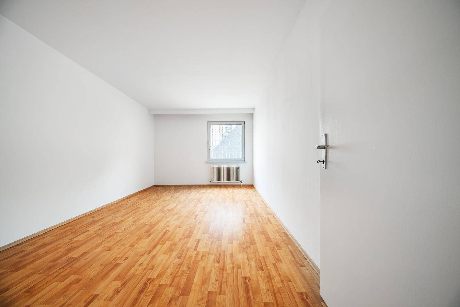Helles Zimmer mit Laminatboden und Fenster, bietet vielseitige Nutzungsmöglichkeiten.