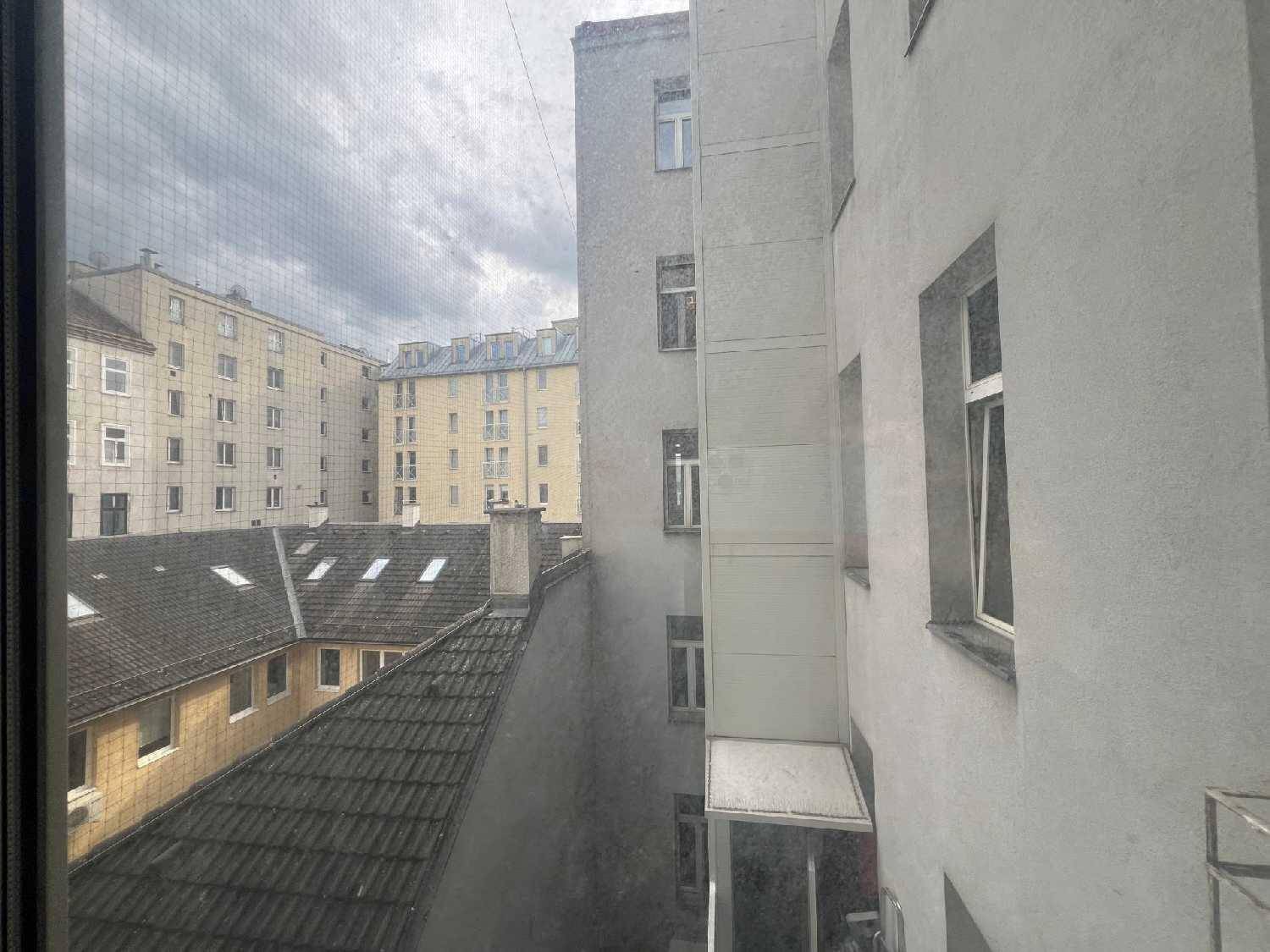 Blick aus dem Fenster auf die Dächer und Fassaden der umliegenden Gebäude.