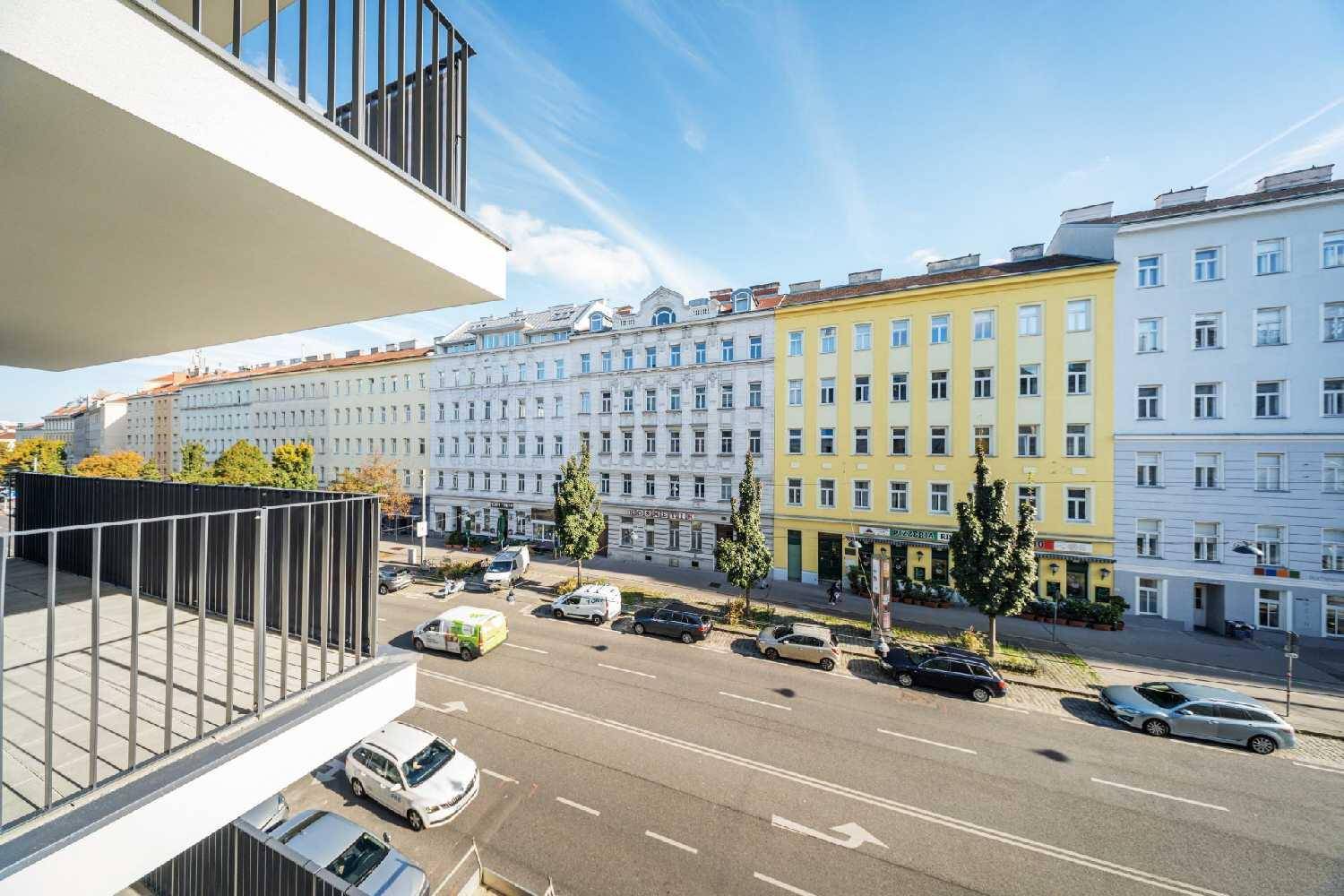 Weitläufiger Blick von einem Balkon auf eine belebte Stadtstraße mit historischen Gebäuden.