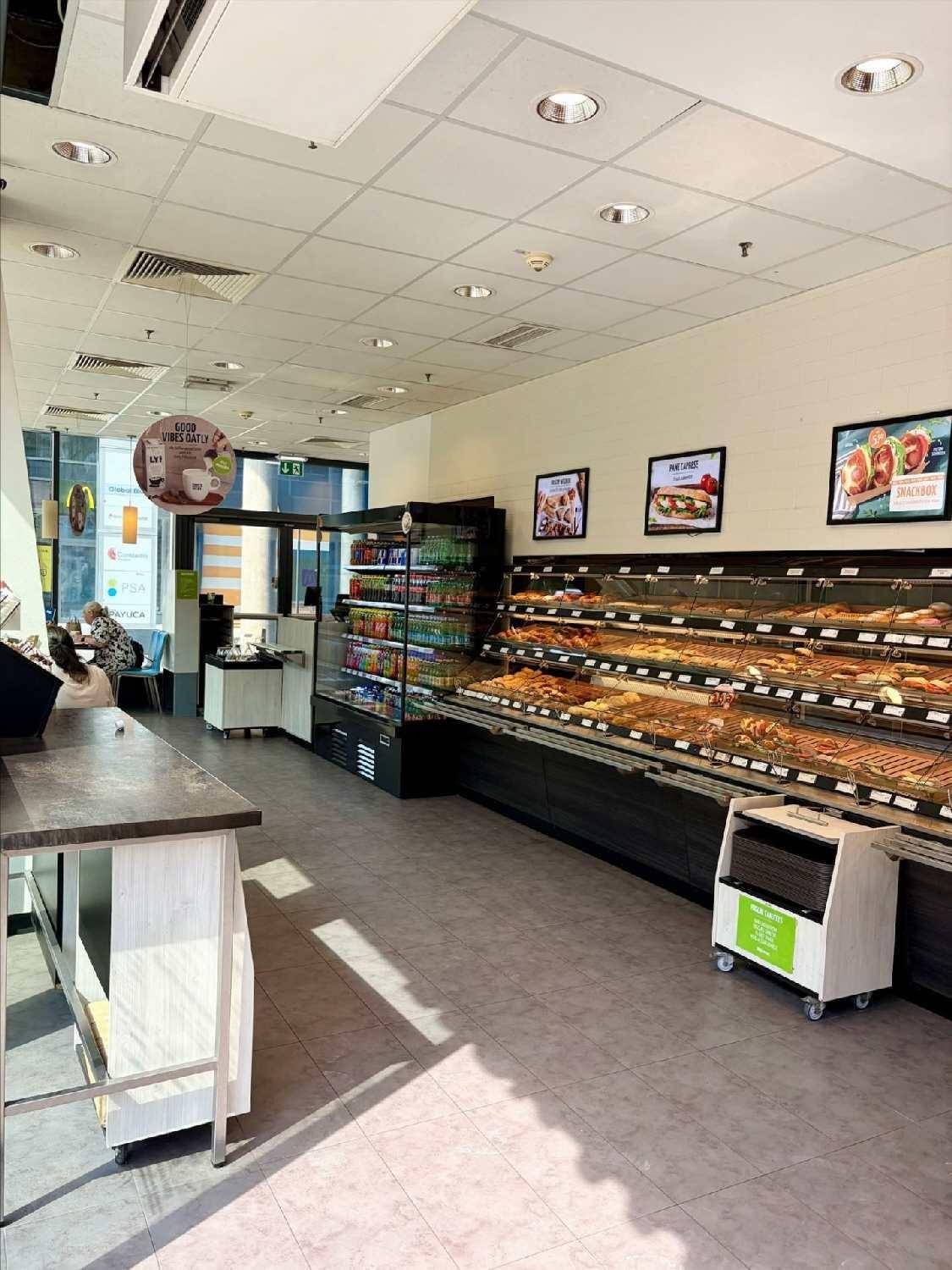 Innenansicht des Bäckerei-Cafés mit Theke, Kühlregalen und einer großen Auswahl an Backwaren.