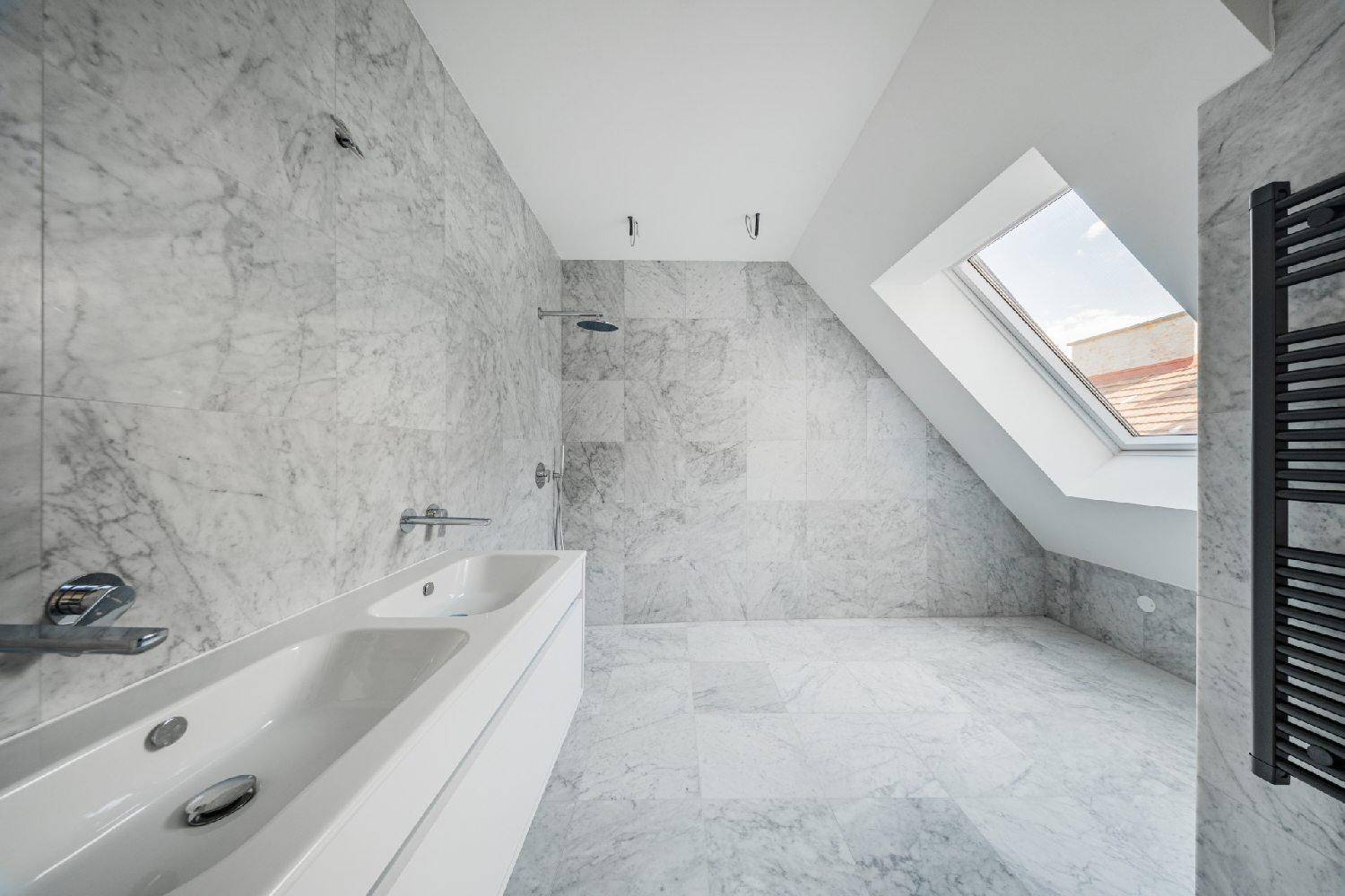 Elegantes Badezimmer mit Marmorfliesen, Doppelwaschbecken, Regendusche und Dachfenster für viel Licht.