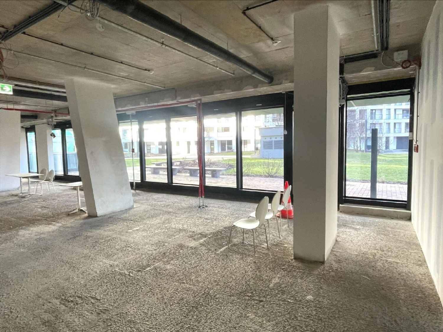 Großer, offener Innenraum mit Betonboden und unverkleideter Decke, bereit für den Ausbau.