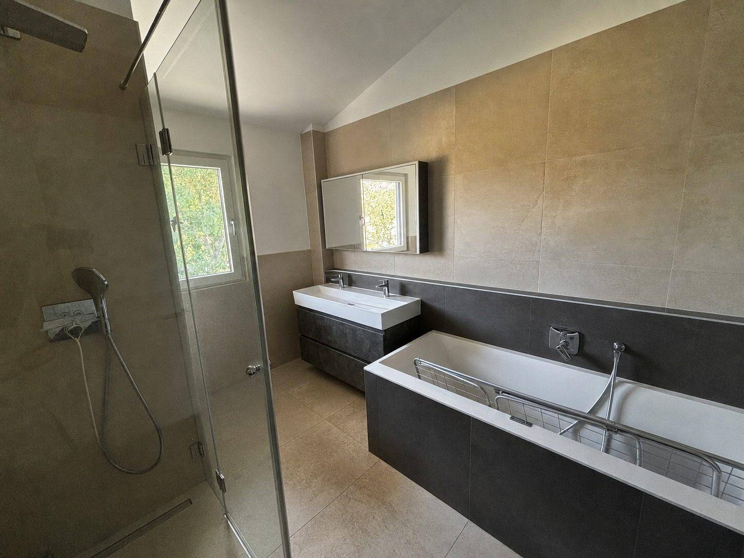 Modernes Badezimmer mit begehbarer Dusche, Doppelwaschbecken und Badewanne.