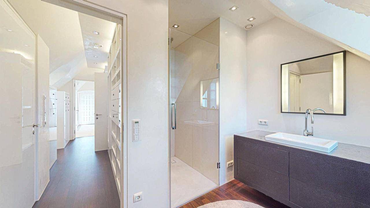 Modernes Badezimmer mit begehbarer Dusche, Einzelwaschbecken und Zugang zum Ankleidezimmer.