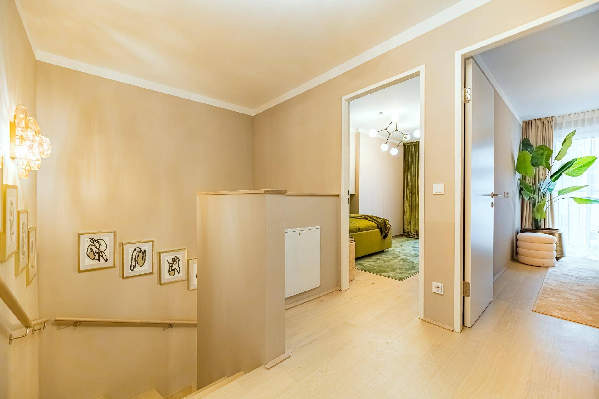 Oberer Flurbereich mit Holztreppe und Zugang zu weiteren Zimmern, hell und modern gestaltet.