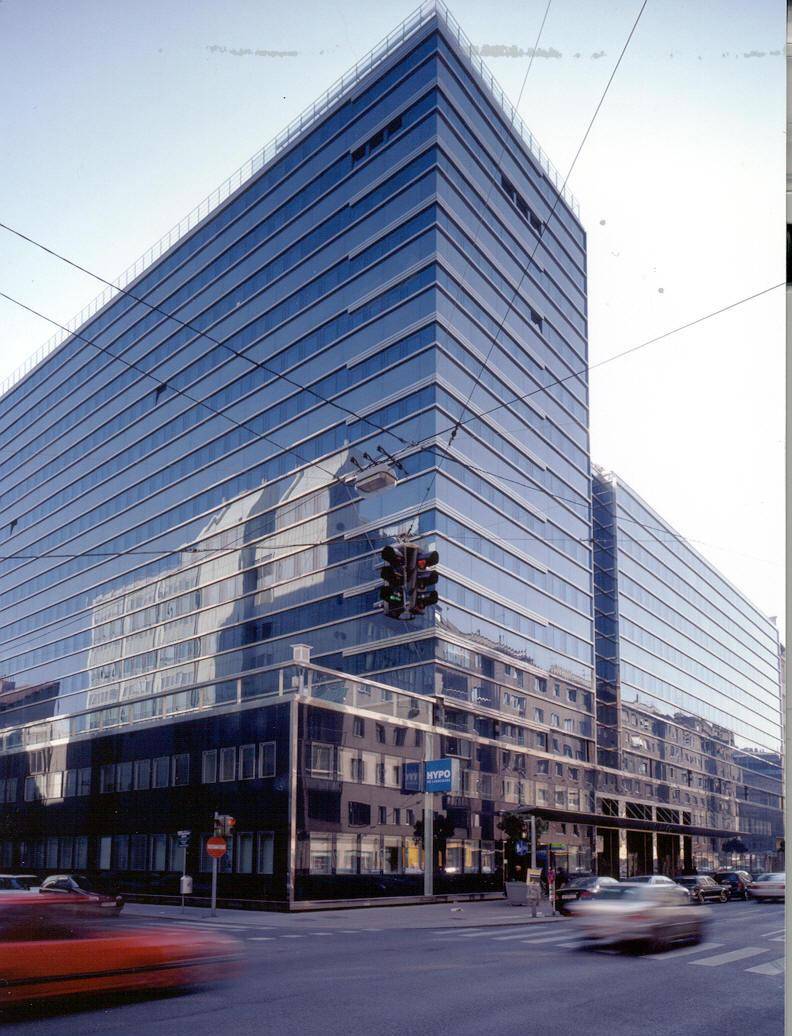 Modernes Bürogebäude mit einer beeindruckenden Glasfassade, die die umliegende Stadt widerspiegelt.