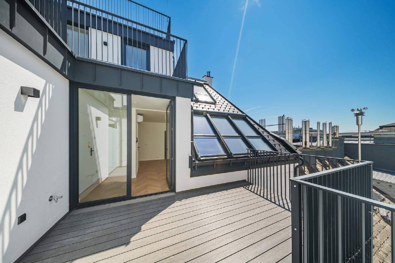 Geräumige Dachterrasse mit Holzboden, Metallgeländer und weitem Blick über die Stadt.