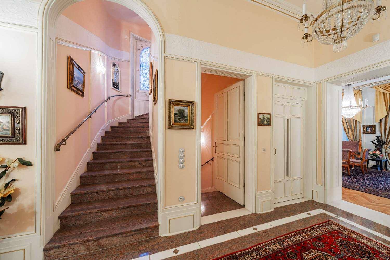 Elegantes Treppenhaus mit Marmorstufen und kunstvollen Geländern, das zu den oberen Etagen führt.