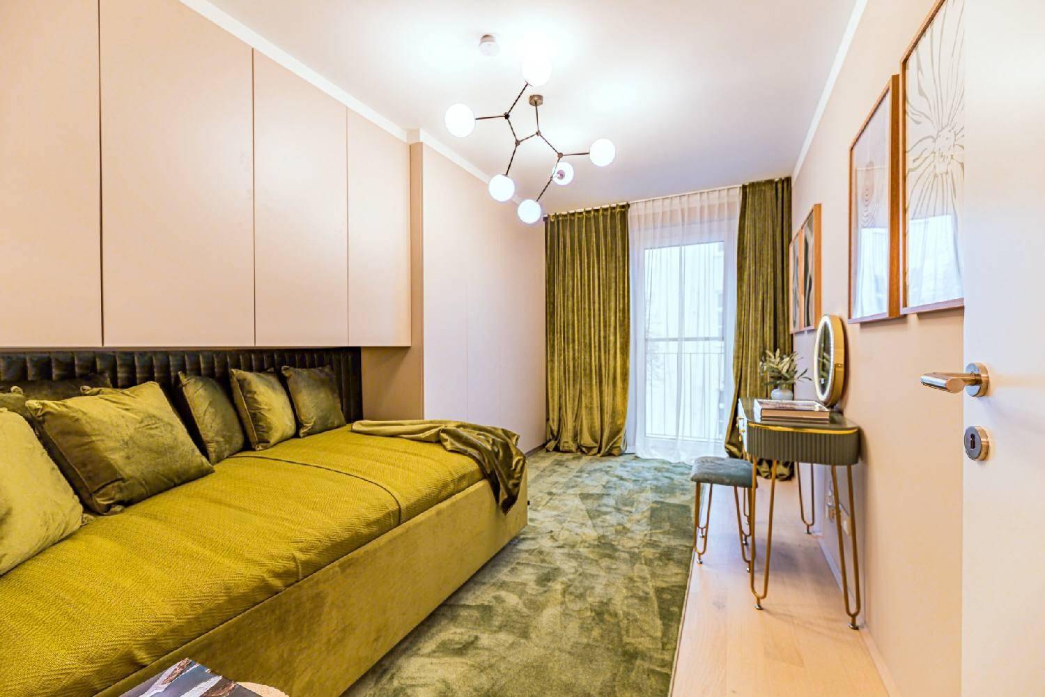 Modernes Schlafzimmer mit grünem Samtbett, Teppich und Zugang zu einem französischen Balkon.