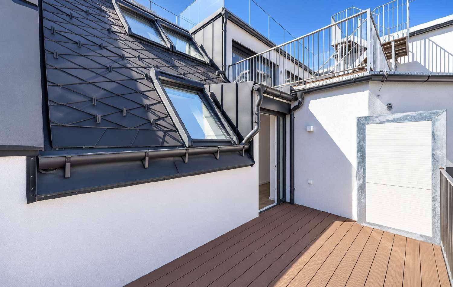 Dachterrasse mit Holzdielen und Blick auf die umliegenden Dächer und den Himmel.