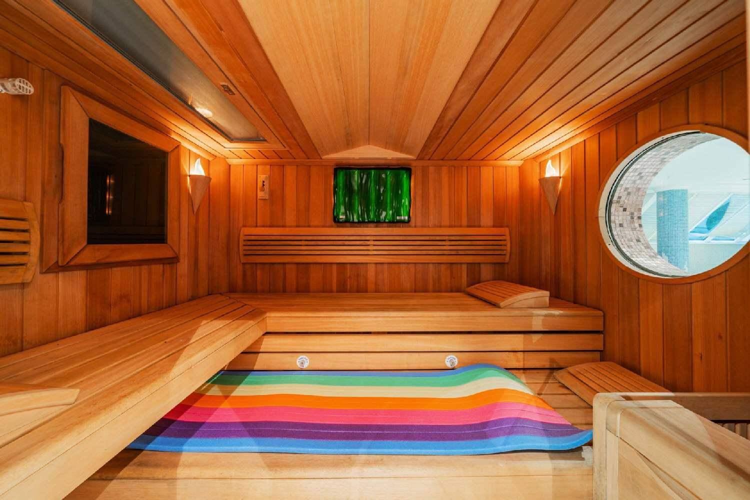 Gemütliche Holzsauna mit Bänken und einem kleinen Fenster, ideal zur Entspannung.