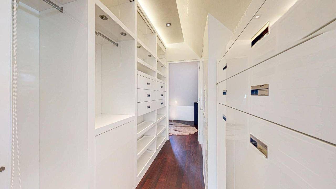 Geräumiger begehbarer Kleiderschrank mit vielen Einbauschränken und Stauraum.