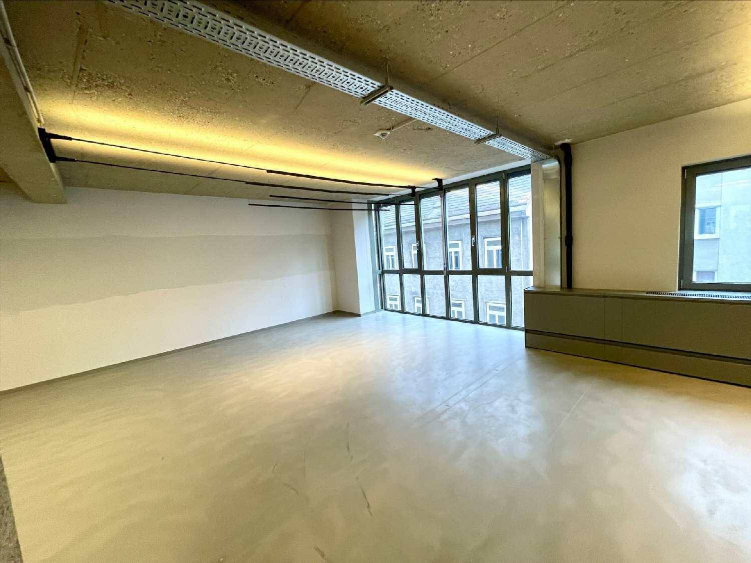 Heller Büroraum mit großen Fenstern und Blick auf die umliegenden Gebäude.