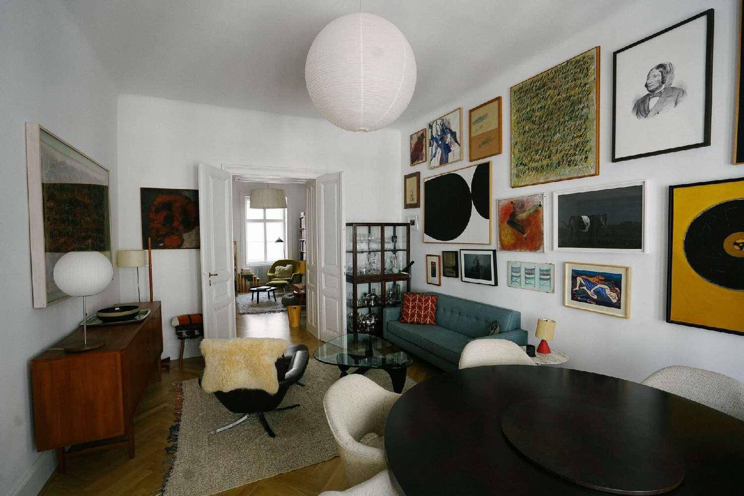 Geräumiges Wohn- und Esszimmer mit vielfältiger Kunstsammlung und stilvollen Möbeln.
