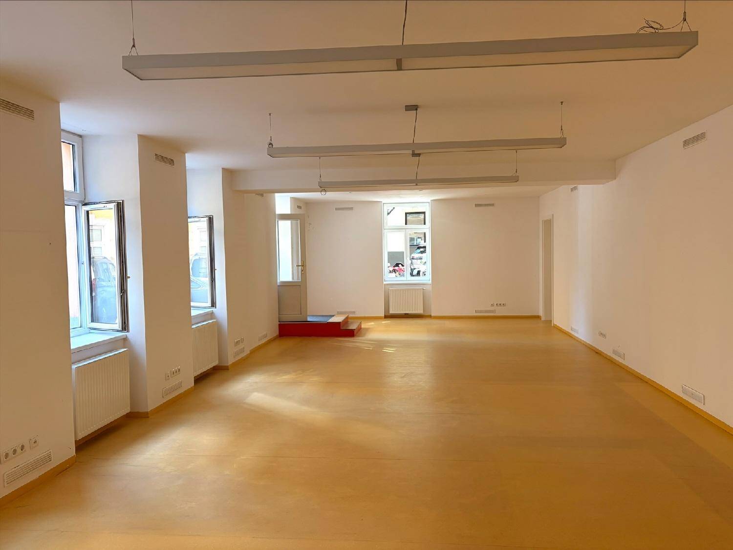 Geräumiger und heller Gewerberaum mit vielen Fenstern, die für eine angenehme Arbeitsatmosphäre sorgen.