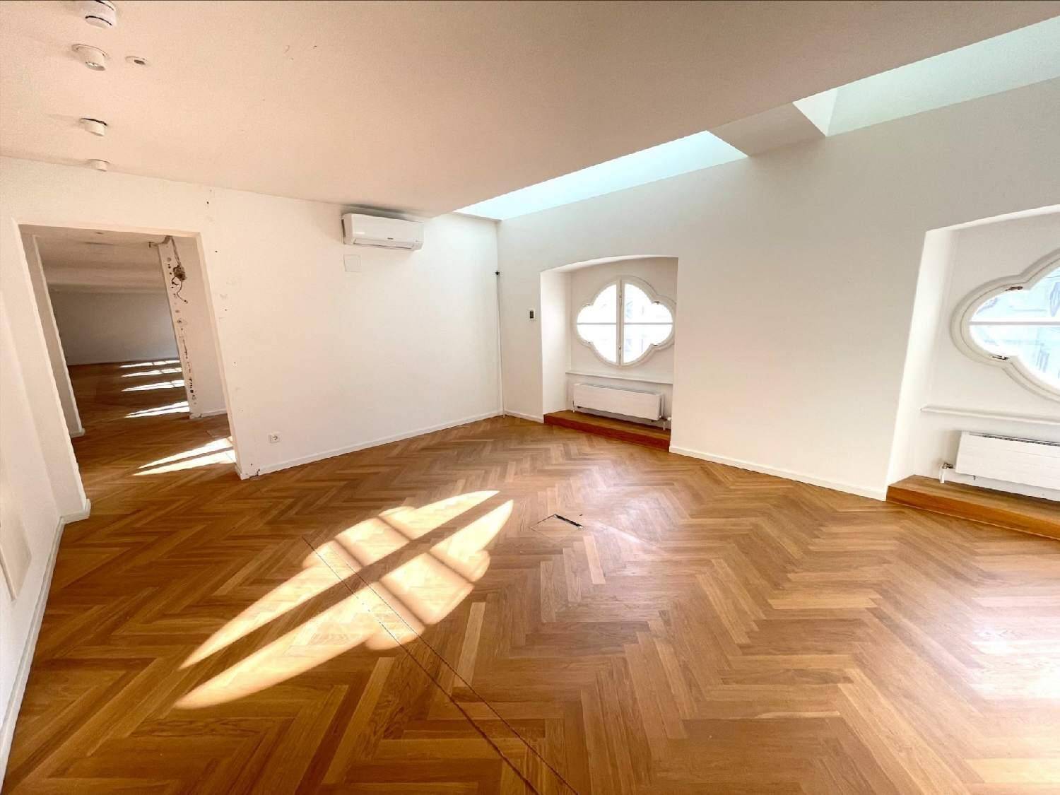 Heller Raum mit Fischgrätparkett, dekorativen Fenstern und viel natürlichem Sonnenlicht.