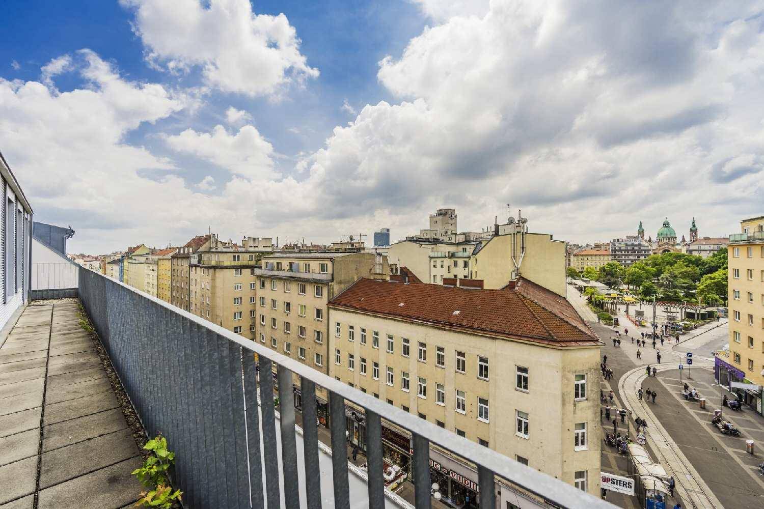 Dachterrasse mit Metallgeländer bietet einen weiten Blick über die Stadt und die umliegenden Gebäude.