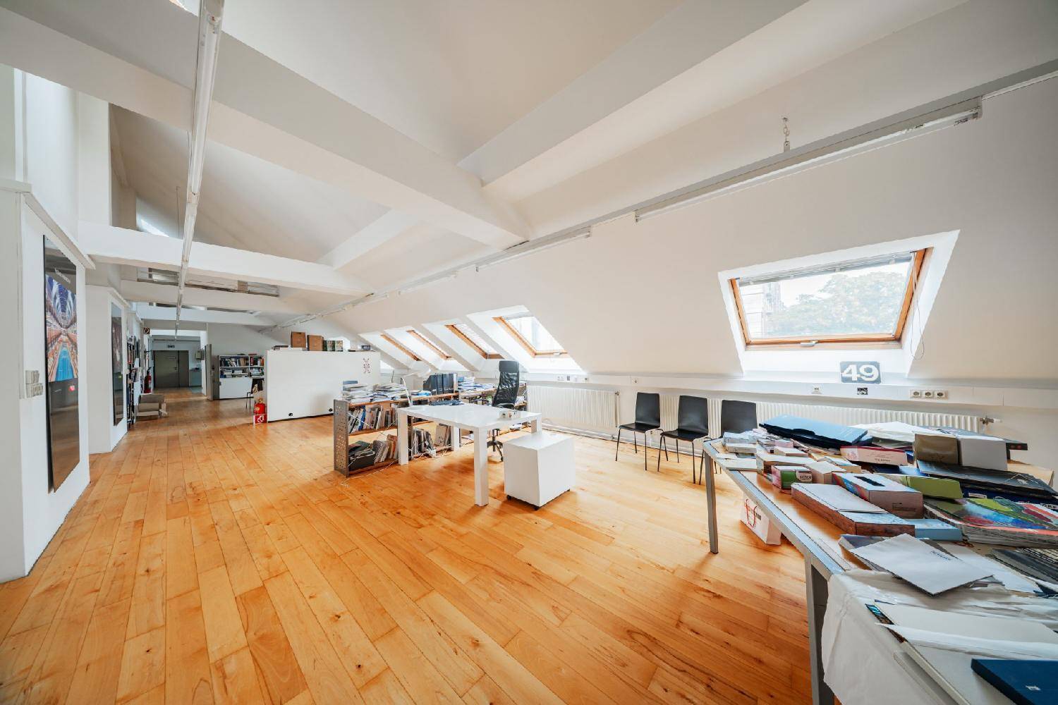 Großes Dachgeschossbüro mit Holzboden, vielen Dachfenstern und offener Raumgestaltung, sehr hell und einladend.