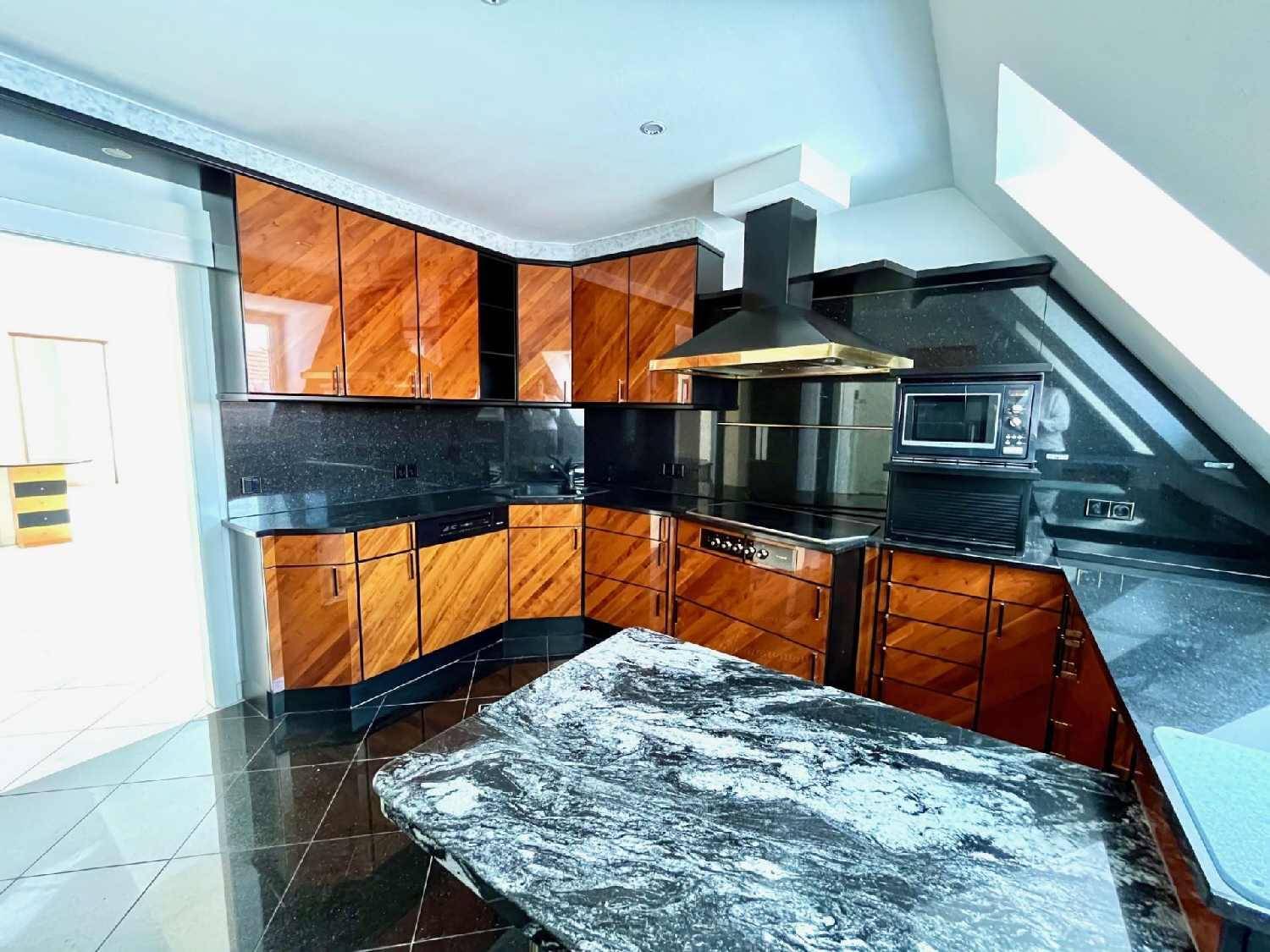 Exklusive Küche mit dunklen Holzfronten, Granitarbeitsplatten und hochwertigen Einbaugeräten.