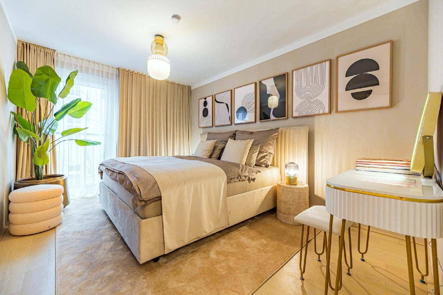 Gemütliches Schlafzimmer mit großem Bett, Teppichboden und modernen Kunstwerken an der Wand.