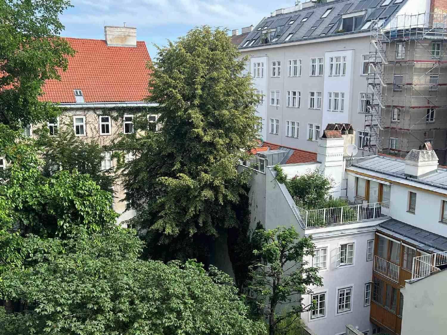 Blick auf begrünte Innenhöfe und umliegende Gebäude mit verschiedenen Dachformen in der Stadt.