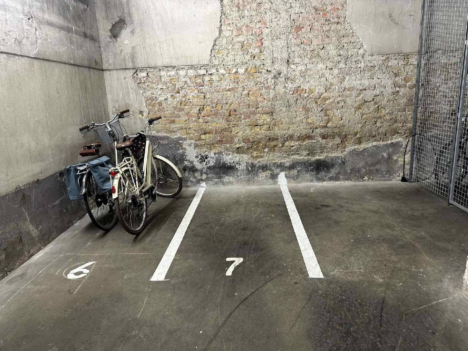 Tiefgaragenstellplatz Nummer 7 mit Fahrrädern und einer unverputzten Ziegelwand.