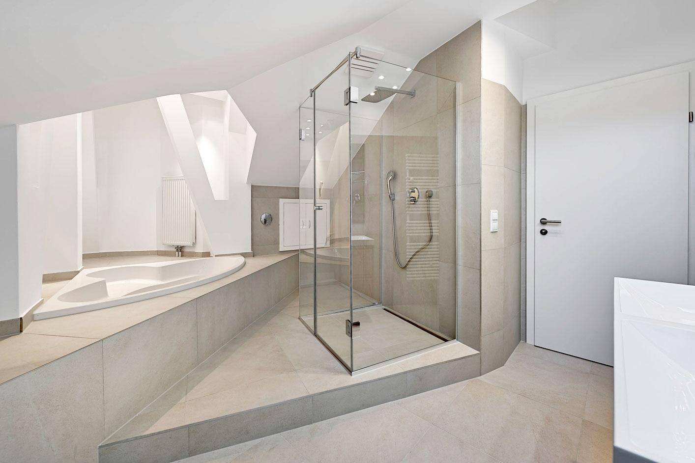 Modernes Badezimmer mit großer Dusche, Badewanne und hellen Fliesen.