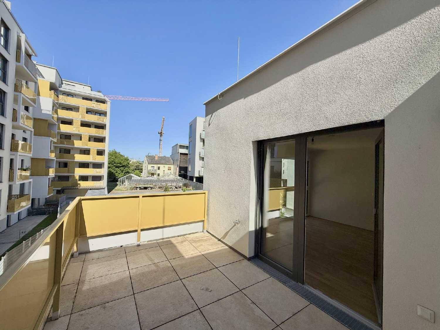 Sonniger Terrassenbereich mit gelbem Geländer und direktem Zugang zum Innenraum der Wohnung.