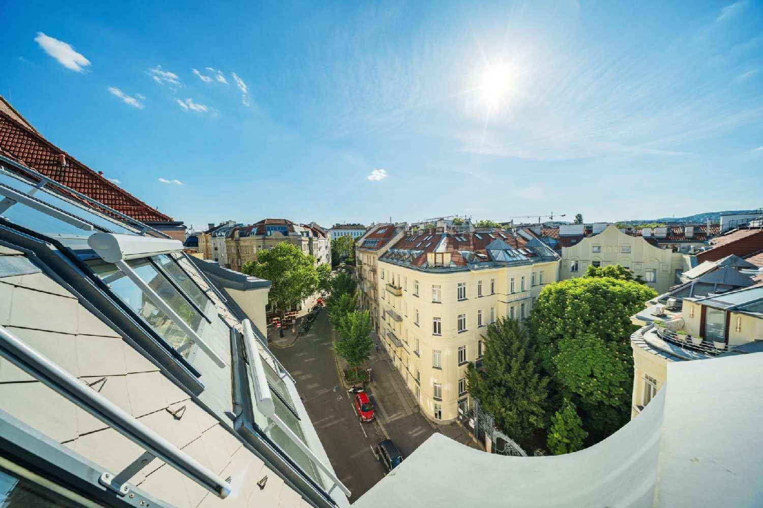 Blick von oben auf eine belebte Stadtstraße mit historischen Gebäuden und viel Grün.
