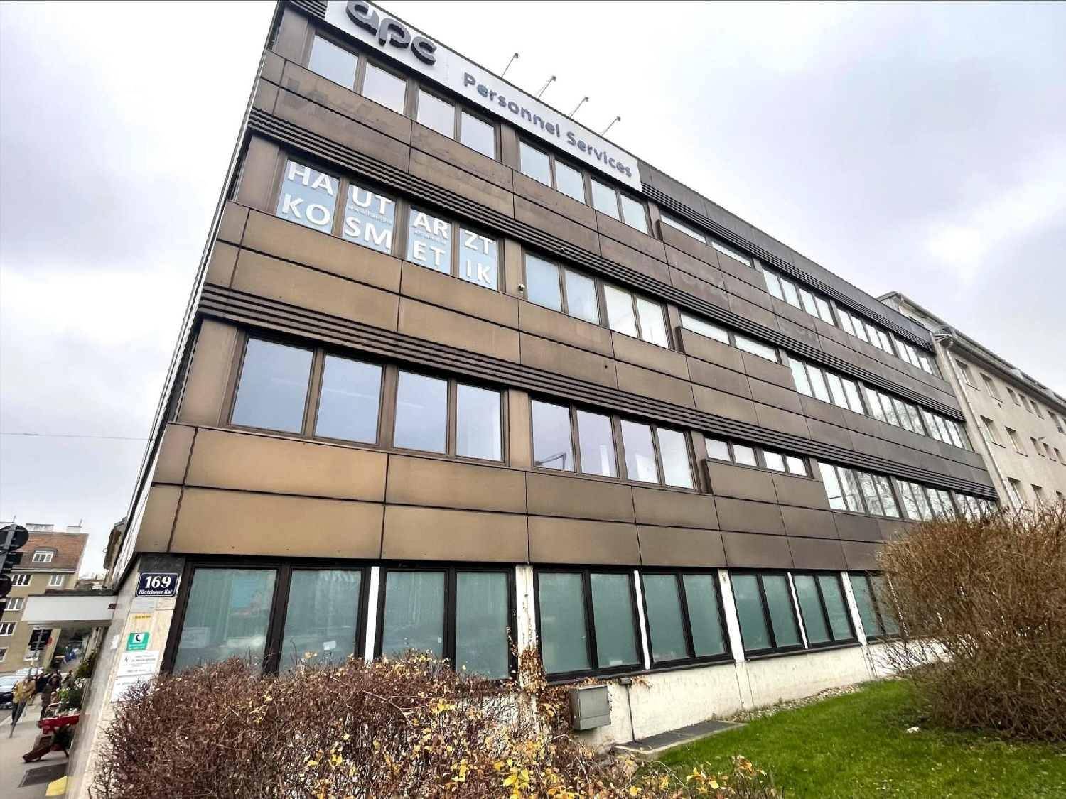 Mehrstöckiges Bürogebäude mit brauner Fassade, großen Fenstern und der Hausnummer 169.